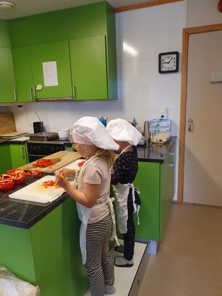 Unger som står og lager mat på kjøkkenet
